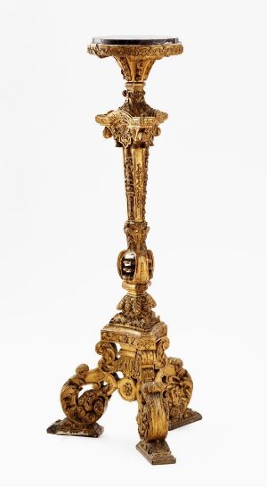  An ornate hexagonal-column pedestal made of carved, gilt oak, with a potentially marble top, standing on a triad of elaborately decorated legs. Artist and title are unknown.