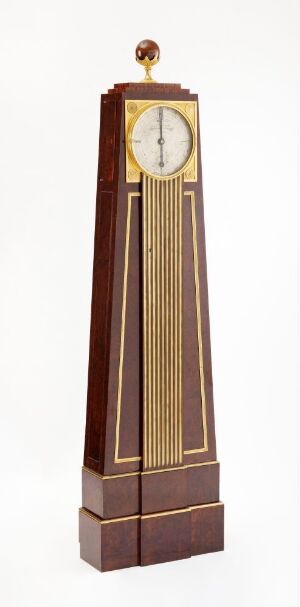  An antique tall-case clock with a polished wooden body, a white circular clock face with Roman numerals at the top, a glass panel showing internal mechanics, and golden accents on a white background. Artist name and title are unknown.