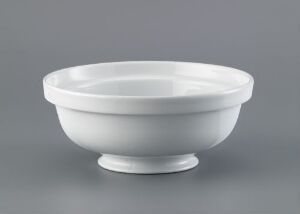  A glazed porcelain bowl by Porsgrunds Porselænsfabrik AS from the "Korulenserviset" collection, featuring a broad rim, a shallow body, and a rounded foot, displayed against a neutral gray background.