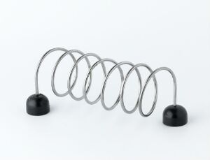  A metallic silver slinky toy with black hemispherical bases at both ends, displayed against a light gray background. The coils of the slinky reflect light, creating a gradient of brightness along the spiraling metal.