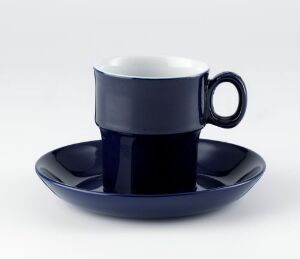  A navy blue porcelain cup and saucer set known as "Korulenserviset" by Porsgrunds Porselænsfabrik AS, with the cup having a glossy exterior and a white interior, placed centrally on the coordinating navy blue saucer.