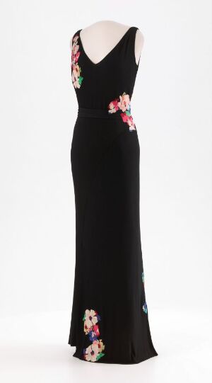  "Séduction" by House of Worth, a black silk floor-length dress with a deep V-neckline and floral appliqués in shades of pink, red, and green on the waist and side, crafted using machine and hand sewing techniques on machine-woven silk jersey.