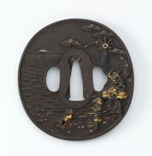  An intricately designed Japanese tsuba (sword hand guard) made of dark metal with gold inlay, depicting a landscape scene with a tree and floral elements, emphasizing masterful metalwork and attention to detail.