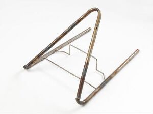  A sculptural piece of furniture titled "Ekstrem" designed by Terje Ekstrøm, made from bent steel tubes with a metallic finish showcasing shades from silver to bronze, displayed against a white background.