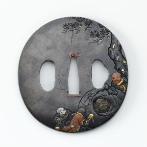  An image of a round, grey metal object with scalloped edges, believed to be a Japanese sword hand guard, featuring embossed golden motifs, two central symmetrical elliptical openings, and dark ink etchings of foliage at the top left corner, exhibiting a blend of elegance and traditional craftsmanship.