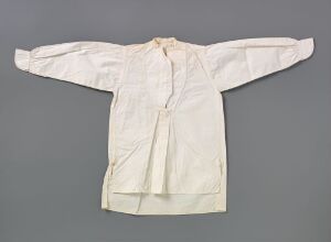  A traditional white shirt with long, wide sleeves laid out on a grey background. The shirt has a round collar and a front button placket.