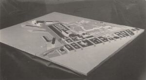 Black and white photograph of an architectural drawing on a drafting board, surrounded by drafting tools, capturing a moment of the architectural design process in a monochromatic silver gelatin print.