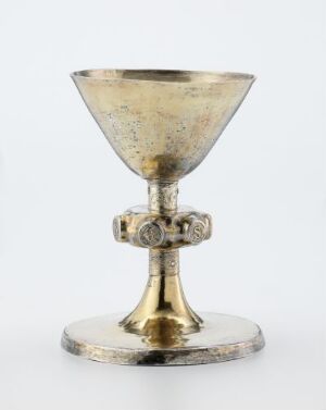  An unidentified artist's ecclesiastical object titled "Alterkalk," a gilded silver chalice with engraved designs on its base and stem, set against a white background, denoting its use in religious ceremonies and reflecting skilled metalwork craftsmanship.