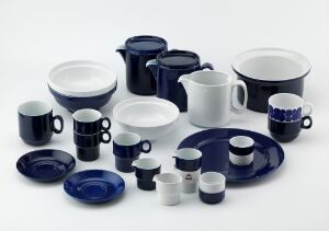  An assorted tableware set by Porsgrunds Porselænsfabrik AS called "Korulenserviset," consisting of porcelain items with a glaze of deep blue and white, including cups, saucers, bowls, and pitchers, arranged on a white surface.