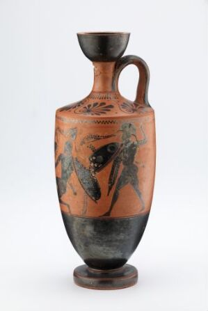  An ancient Greek amphora vase with two handles, displaying black-figure decoration on an orangish-red clay background. There are two main figures depicted in black silhouette with intricate details, surrounded by bands of decorative motifs on the body, with a black flaring mouth and foot. The artistry is indicative of ancient Greek ceramic traditions.