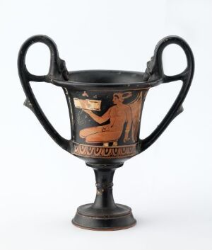  An ancient Greek black-figure kylix with two handles. It features a seated terra cotta red figure in the center, surrounded by decorative patterns above and below, set against a background of polished black glaze.