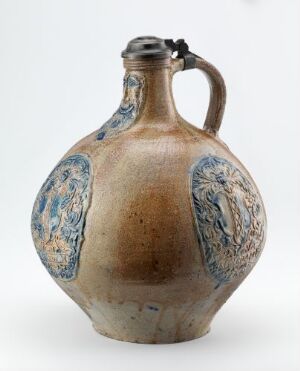  A spherical ceramic jug with a short neck and flared opening, featuring cobalt blue decorative patches on a beige background and a single dark-toned handle, set against a light gray backdrop.