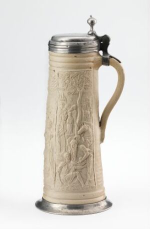  A cylindrical stoneware tableware item with a salt glaze, titled "Den barmhjertige samaritan" by an unknown artist. It features sculpted relief decorations depicting a scene along its surface. The piece has a cast pewter lid and foot, adding a metallic accent to the textured body.