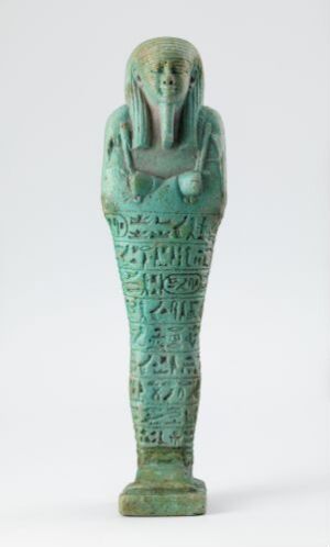  A glaze-finished ancient Egyptian shabti figurine from the grave of Psamtek-mery-Ptah, with a turquoise blue-green color and hieroglyphic inscriptions, representing an overseer of royal ships holding agricultural implements.