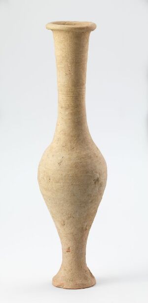  A simple, elongated beige-toned ceramic vase with a textured finish stands against a white background. The vase has a long neck, a rounded body, and a narrow base.