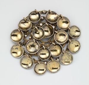  A collection of antique gold-colored round bells of various sizes, interconnected to form a circular shape, displayed against a light grey background.