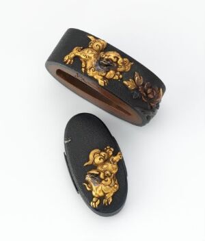  Two intricately carved objects, one a black oval bangle with gold embossed mythical creatures, and the other a matching black and gold cover or lid, placed on a light gray background.