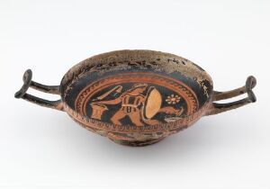  Ancient Greek kylix with black-figure decoration, displaying intricate mythological scenes against a terracotta backdrop, flanked by two horizontal black handles.