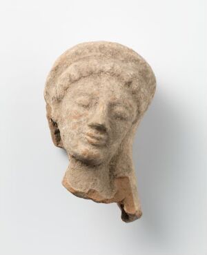  An ancient, stylized stone or clay sculpture of a human head with wavy hair, almond-shaped eyes, a straight nose, and a slightly parted mouth, colored in homogeneous beige against a neutral light grey background. Artist name and title are unknown.