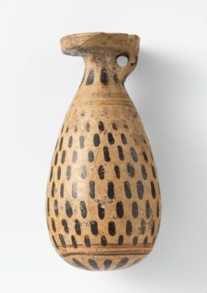  A slender ceramic jug with a flared mouth and single handle, displaying a light beige background with a dense pattern of dark brown or black teardrop markings.