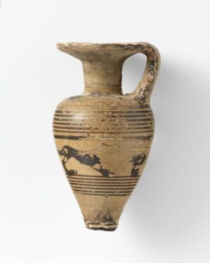  An ancient, beige-colored ceramic jug with a curving handle, decorated with horizontal bands and stylized brown or black animal and possibly human figures, indicating its historical and cultural significance. The jug is set against a light background.