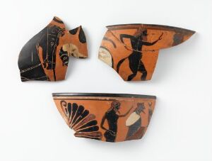  Three broken pieces of ancient Greek pottery with black-figure paintings on a terracotta background, depicting portions of humans and a horse.