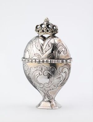  A silver, egg-shaped decorative container with intricate embossed floral patterns and a crown-like finial on top, set against a plain white background.