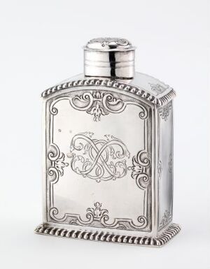  An ornate, vintage silver flask with embossed scrollwork and a central monogram on a white background.