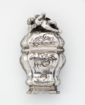  An ornate, silver-colored baroque container with a figurine of a sleeping cherub on the lid, featuring detailed floral engravings, set against a light, neutral background. Artistname and title are unknown.