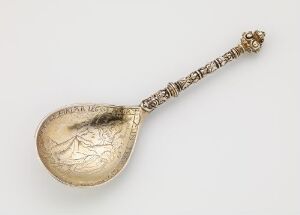  An antique "forgylt sølv" (gilt silver) spoon titled "Skje" by an unidentified artist, featuring a rounded bowl with ornate engravings and a decorative handle culminating in a detailed finial, showcasing exquisite craftsmanship and design.