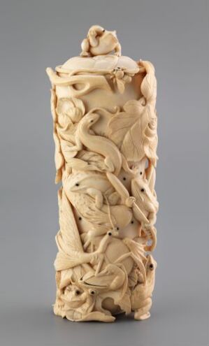  A vertically positioned, intricately carved ivory-like object displaying a detailed relief scene with figures of humans and animals in a narrative arrangement, enhanced by the creamy beige tones and natural variations suggesting age. Artist name and title remain unknown.