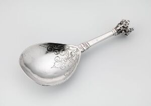  A silver spoon named "Sølvskje" by Jochim Haveman placed on a plain background. The spoon features an elegantly engraved handle with a detailed end, showcasing the reflective, polished quality of