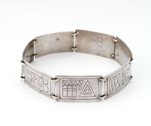  A silver bracelet with geometric designs displayed against a light background.