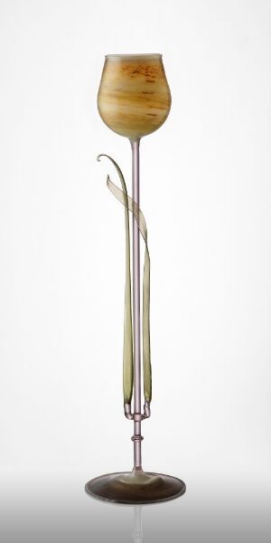  A tall, elegant glass object with a bulbous honey-colored top that fades to translucent, attached to a slender, reed-like metallic stem and a dark brown base, set against a light grey background. Artist name and title are unknown.