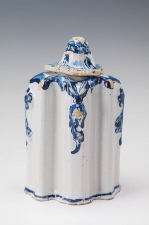  A white-glazed fajanse tableware piece by Andreas Rosendal, with hand-painted cobalt blue floral designs, featuring fluted vertical texture and a peaked lid.