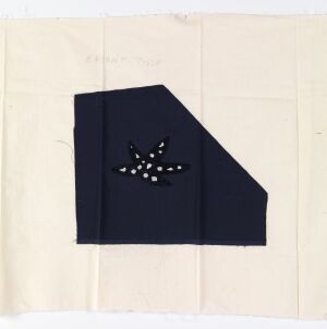  A square-cut piece of navy blue silk fabric with white machine-embroidered design, resembling a constellation of stars, is placed on a cream cotton background. This is a work by Per Spook, part of a costume design utilizing silk satin with machine embroidery.