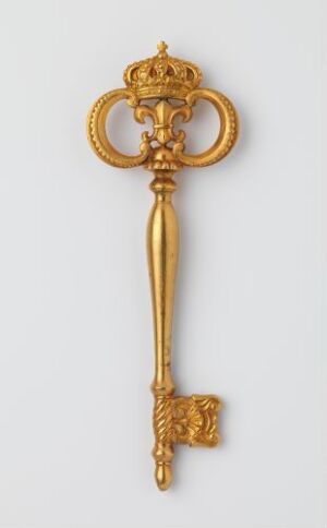  Gilded bronze key "Kammerherrenøkkel" by an unidentified artist, featuring an ornate crown motif at the top and detailed relief work along the shaft and bit, displayed against a plain light background.