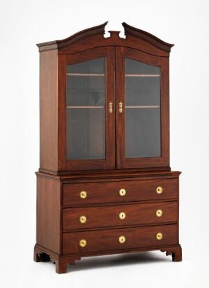  A mahogany and oak stained Bokskap, or storage cabinet, by an unidentified artist with glass-paneled doors, brass fittings, and a decorative arch, against a neutral background.