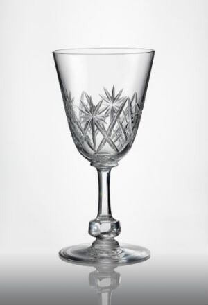  An intricately cut and faceted decorative glass goblet, boasting a blown glass construction with a skilfully etched star or snowflake pattern on the transparent bowl, set against a plain gray background. Artist name and title are unknown.