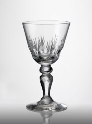  An elegantly decorated, clear blown glass goblet with faceted, olive-cut, and wheel-cut designs, created by an unknown artist. The goblet has a broad bowl, adorned with a detailed cut pattern, supported by a beaded stem and a stable circular base.