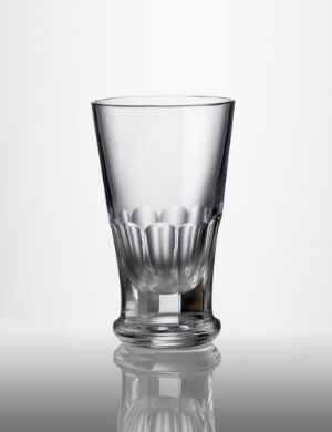  A faceted, blown glass tumbler with a smooth, tapering upper part and a textured, cut-decorated lower third, set against a neutral background, reflecting on the surface below. The artist's name and title of the piece are unknown.