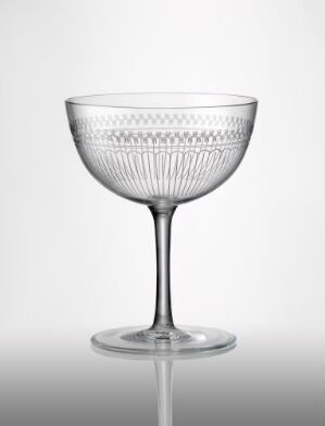  A clear glass coupe with textured vertical ridges on the lower half of the bowl, set against a light gray background. Artist name and title are unknown.