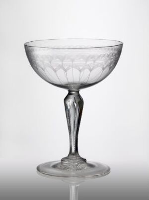  An elegant clear glass goblet made by Hadeland Glassverk, with a blown and polished structure, featuring a bowl with etched petal-like decorations providing a frosted appearance, a slender stem with a central bulge, and a flat, circular base, set against a light grey background.