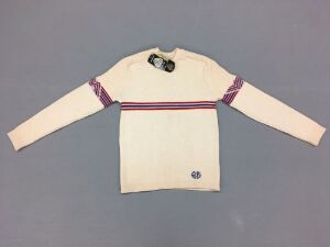  "White woolen machine-knitted sweater with a high collar and zipper, featuring a horizontal flag stripe in red, blue, and white relief across the chest and upper arms, designed by Charles Wolf A/S for the event Ski VM Oslo 1982."