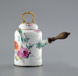  A porcelain chocolate pot with ornate floral designs in multiple colors and a golden handle on the lid, featuring a side handle that appears to be wooden, set against a light gray background. Artist name and title unknown.