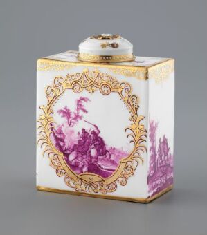  A rectangular porcelain inkwell with cream base color, adorned with purple landscape scenes and golden scrolled frames on the sides, and a round white lid with a golden knob on top.