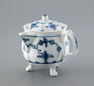  A traditional blue and white porcelain sugar bowl with ornate handles and feet, featuring a cobalt blue floral and filigree pattern against a glossy white background. The bowl has a lid with a small rounded knob at the top. Artist name and title are unknown.