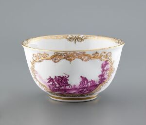  A porcelain bowl with a white body featuring deep purple floral designs opposite each other, complemented by intricate gold scrollwork around the rim and subtle gold patterns between the flowers, set against a neutral backdrop.