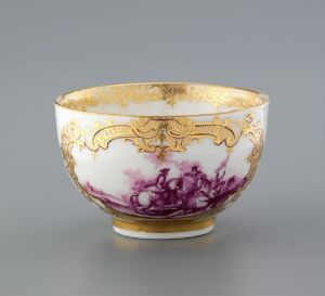  An intricately designed porcelain bowl with a gilded rim and base, featuring a detailed pattern of purple flowers against a white background. Artist name and title are unknown.