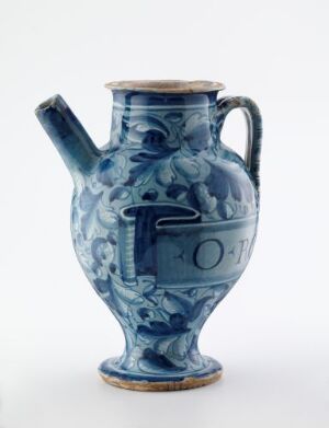  A traditional blue-glazed ceramic pitcher with intricate white and lighter blue floral patterns and a medallion on the front with the word "ROT". The pitcher has a curved handle, a bulbous body, and sits against a clean white background.